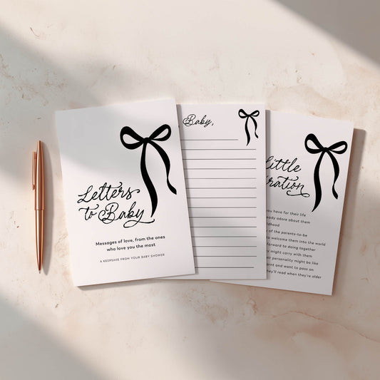 Baby Shower games with decorative black bows and text on a light surface with a pen.