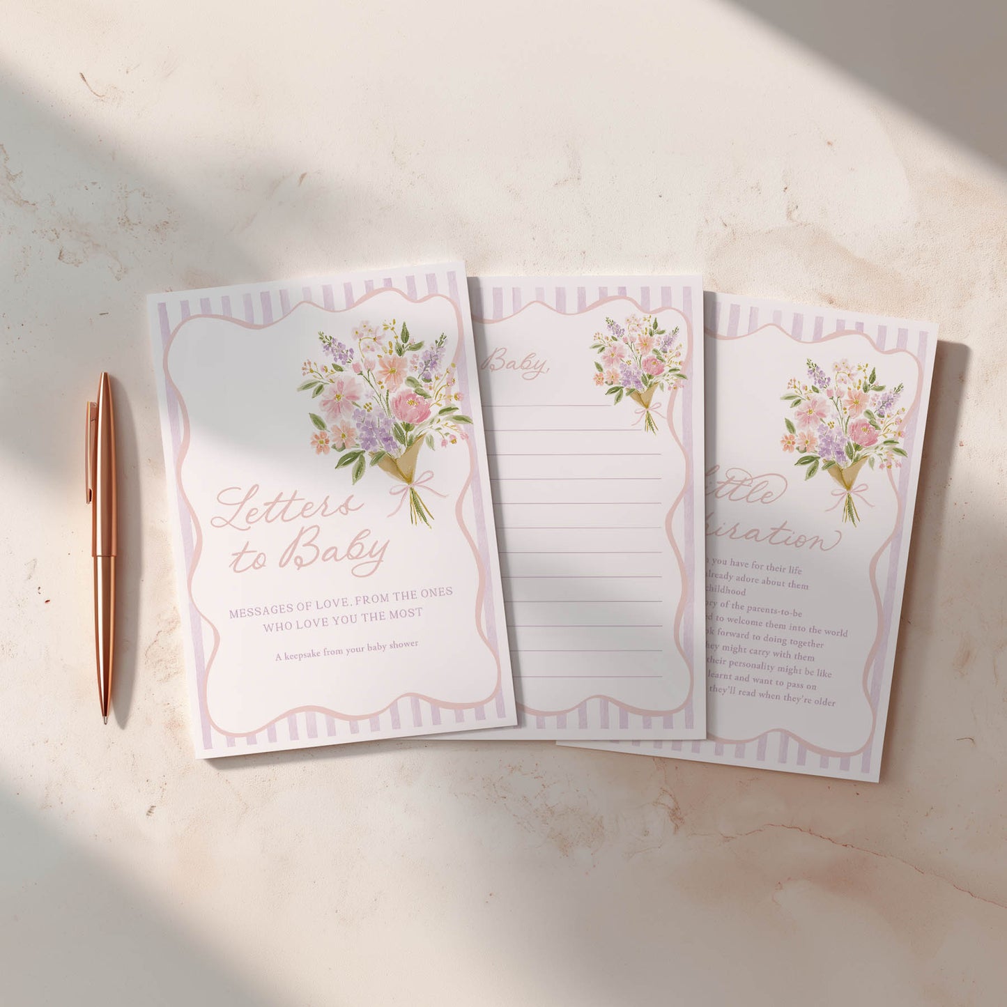 Set of three floral-themed notepads with a pen on a light surface