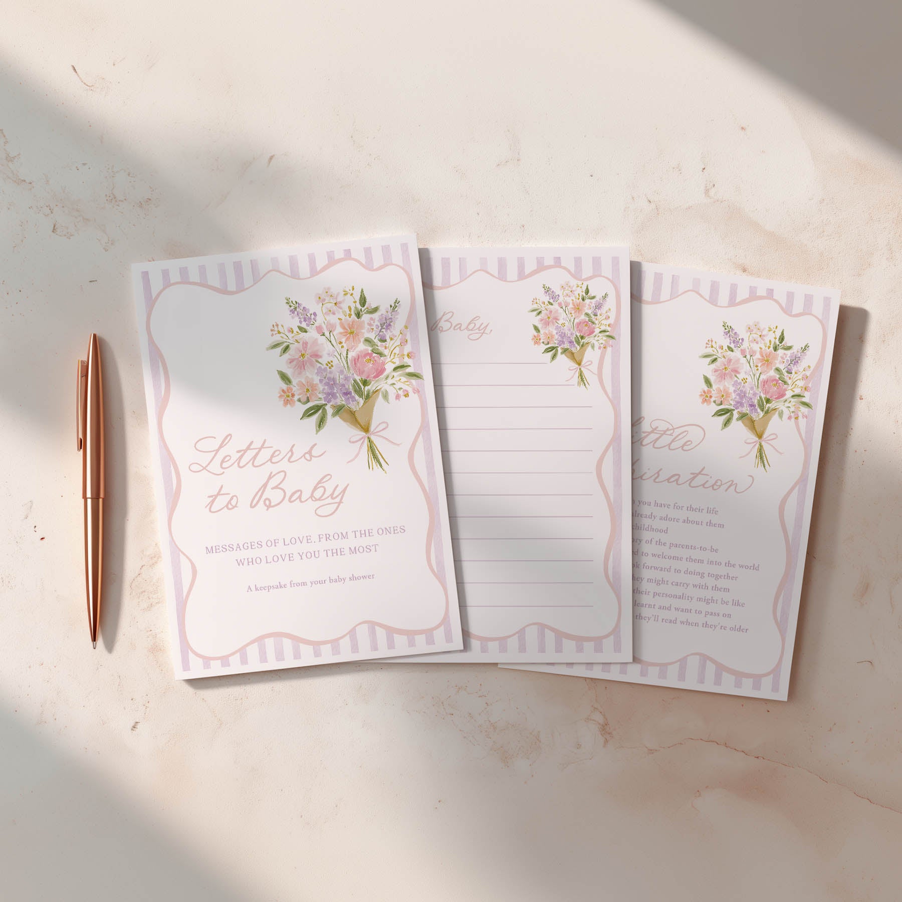 Set of three floral-themed notepads with a pen on a light surface