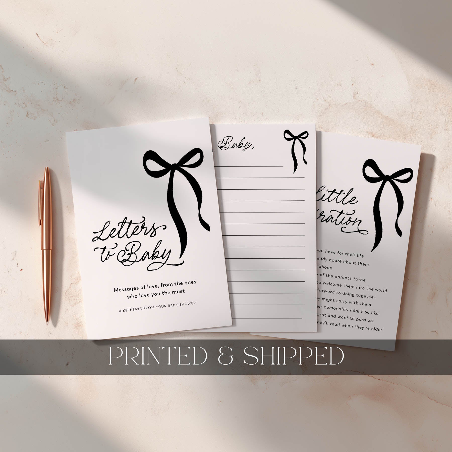 Set of three notebooks with black bow designs and text on a light surface, accompanied by a pen.