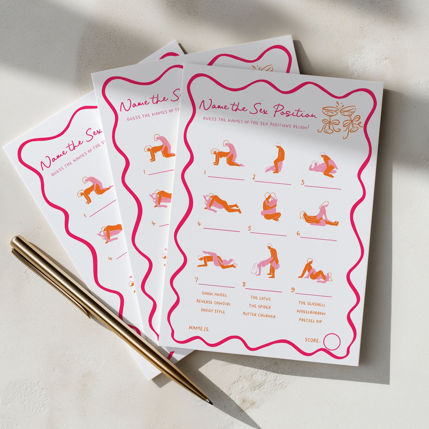 Three printed game cards titled "Name the Sex Position" are fanned out on a light surface, with a gold pen resting on the front card. The cards have a white background with bright pink wavy borders and orange illustrations of sexual positions, plus small instruction-like text and a scoring circle.