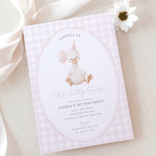 Invitation card for a baby's 1st birthday with a goose illustration on a light pink background.