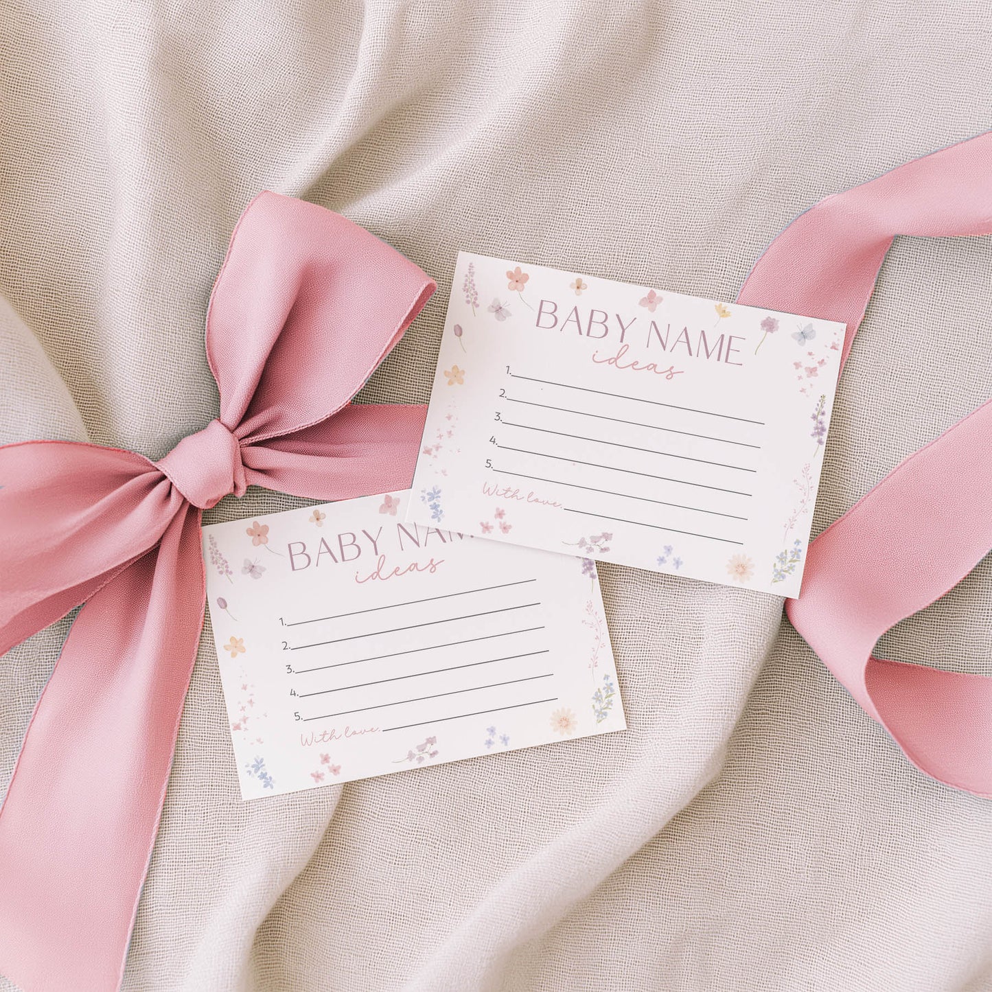 Two floral-themed notepads with 'Family Traditions' text on a beige fabric background with pink ribbons.