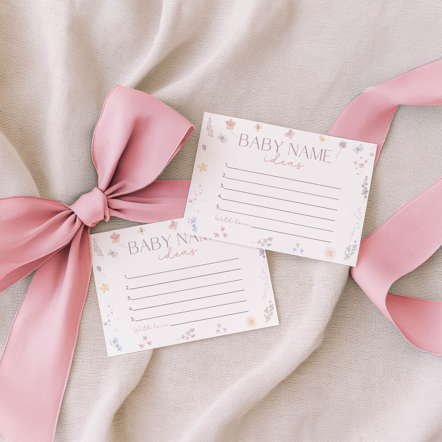 Two floral-themed notepads with 'Family Traditions' text on a beige fabric background with pink ribbons.