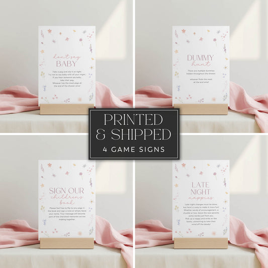 Set of four baby shower game signs with pink ribbons on a neutral background