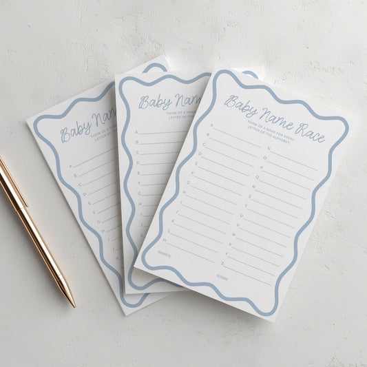 Three baby name lists on a light gray surface with a pen.