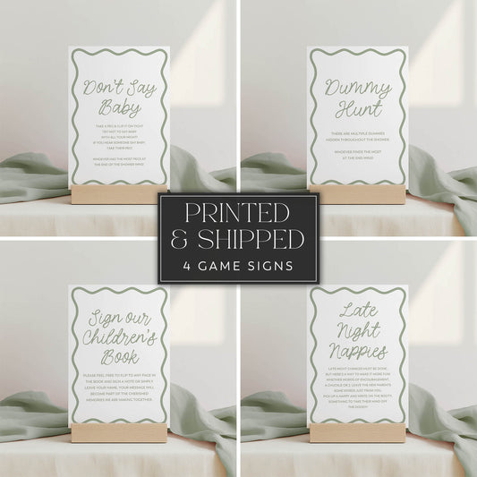 Set of four green wavy baby shower game signs on a neutral background with text.
