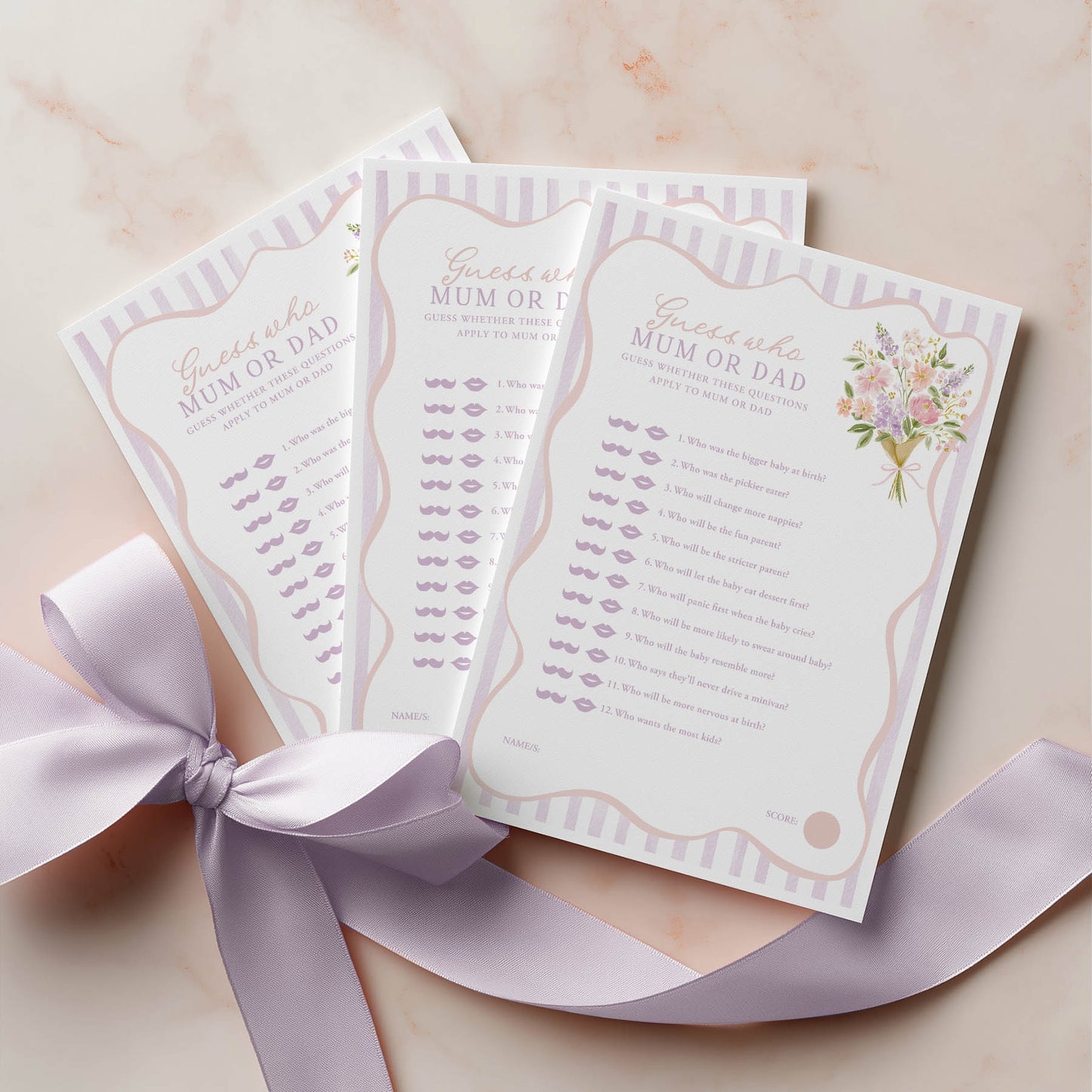 Three baby shower name game cards with a decorative ribbon on a light background