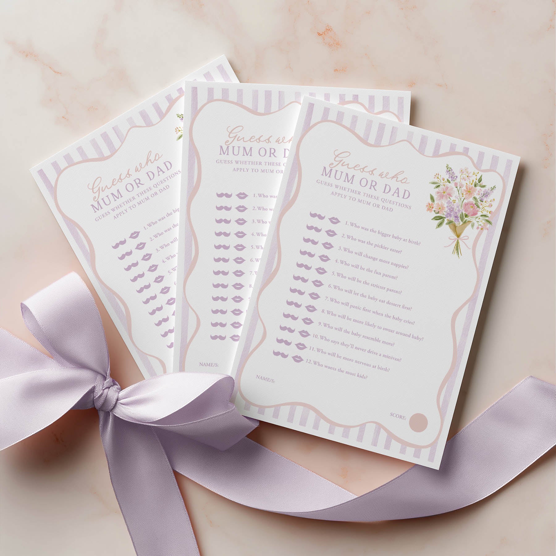 Three baby shower name game cards with a decorative ribbon on a light background