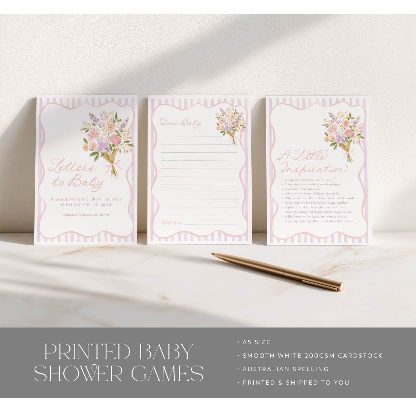 Three printed baby shower games on a marble surface with a pen.