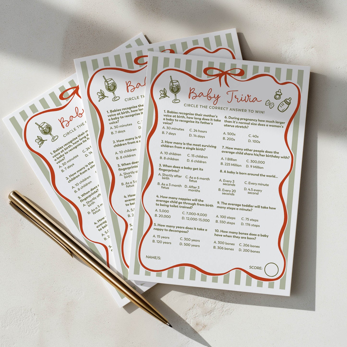 Three ciao baby baby trivia cards with a pen on a light surface green and red