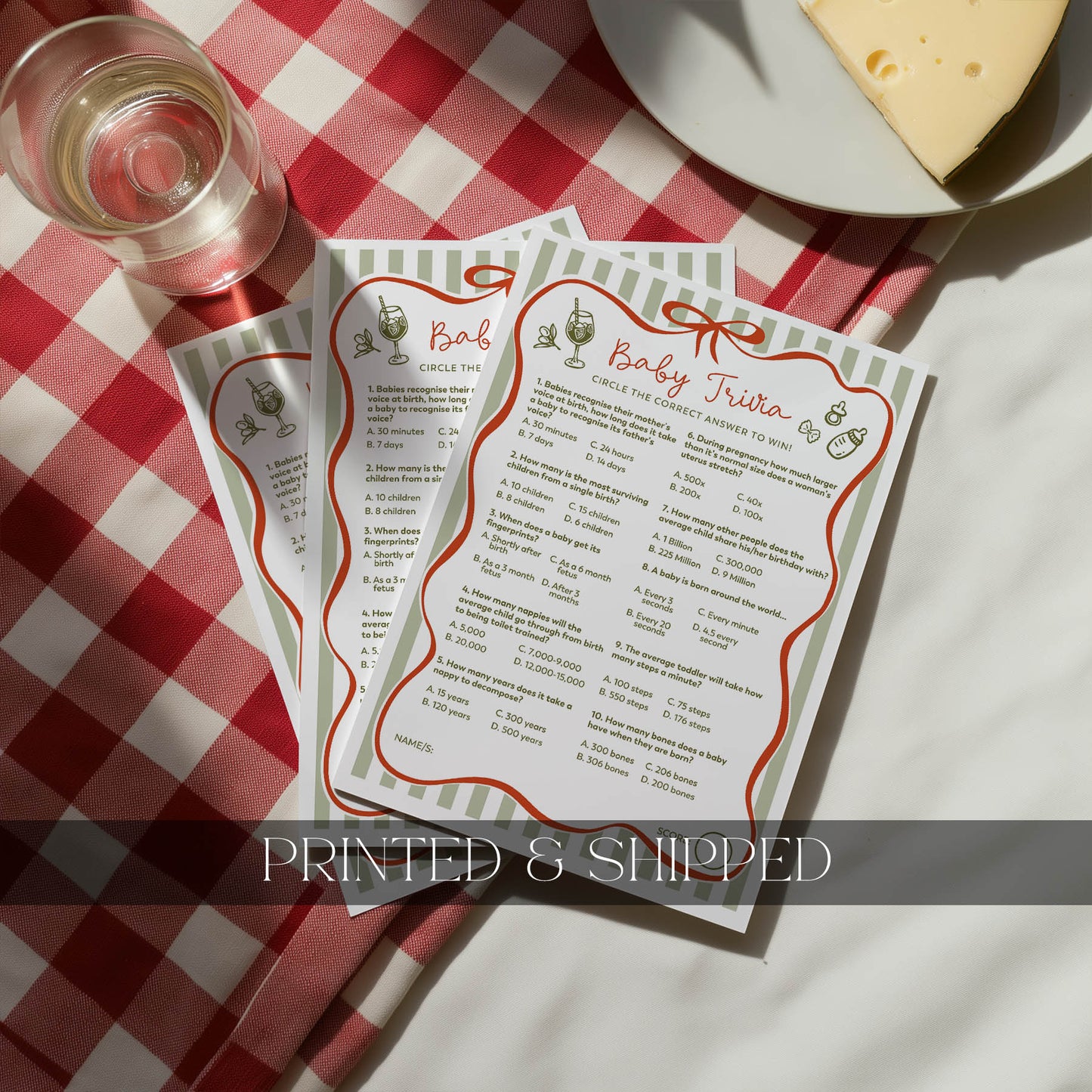 Three printed baby trivia cards with a pen on a light surface, labeled 'Printed & Shipped'.