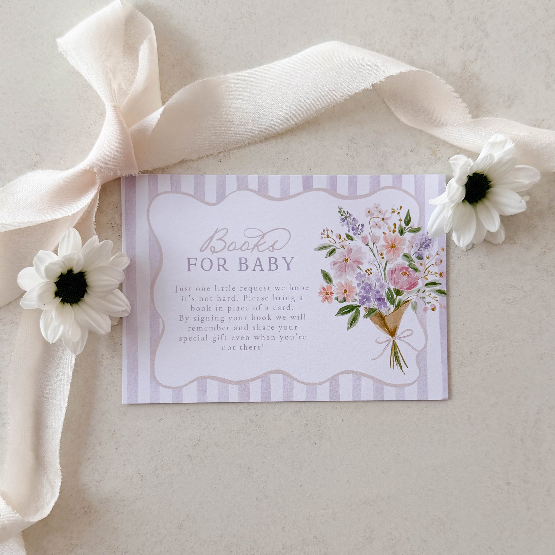 Baby shower invitation with floral design and ribbon on a light background