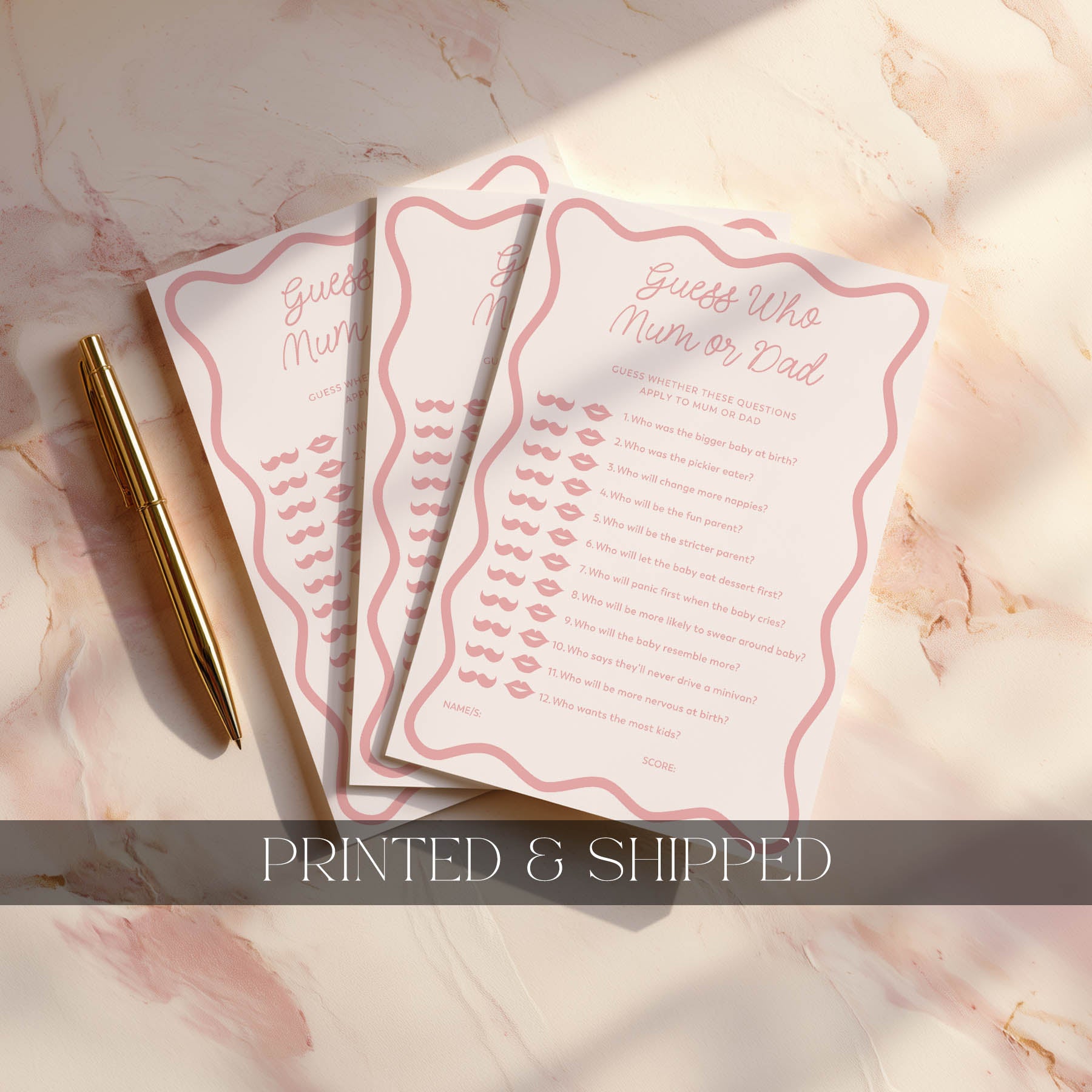 Three pink printed cards with text on a marble surface, accompanied by a gold pen.