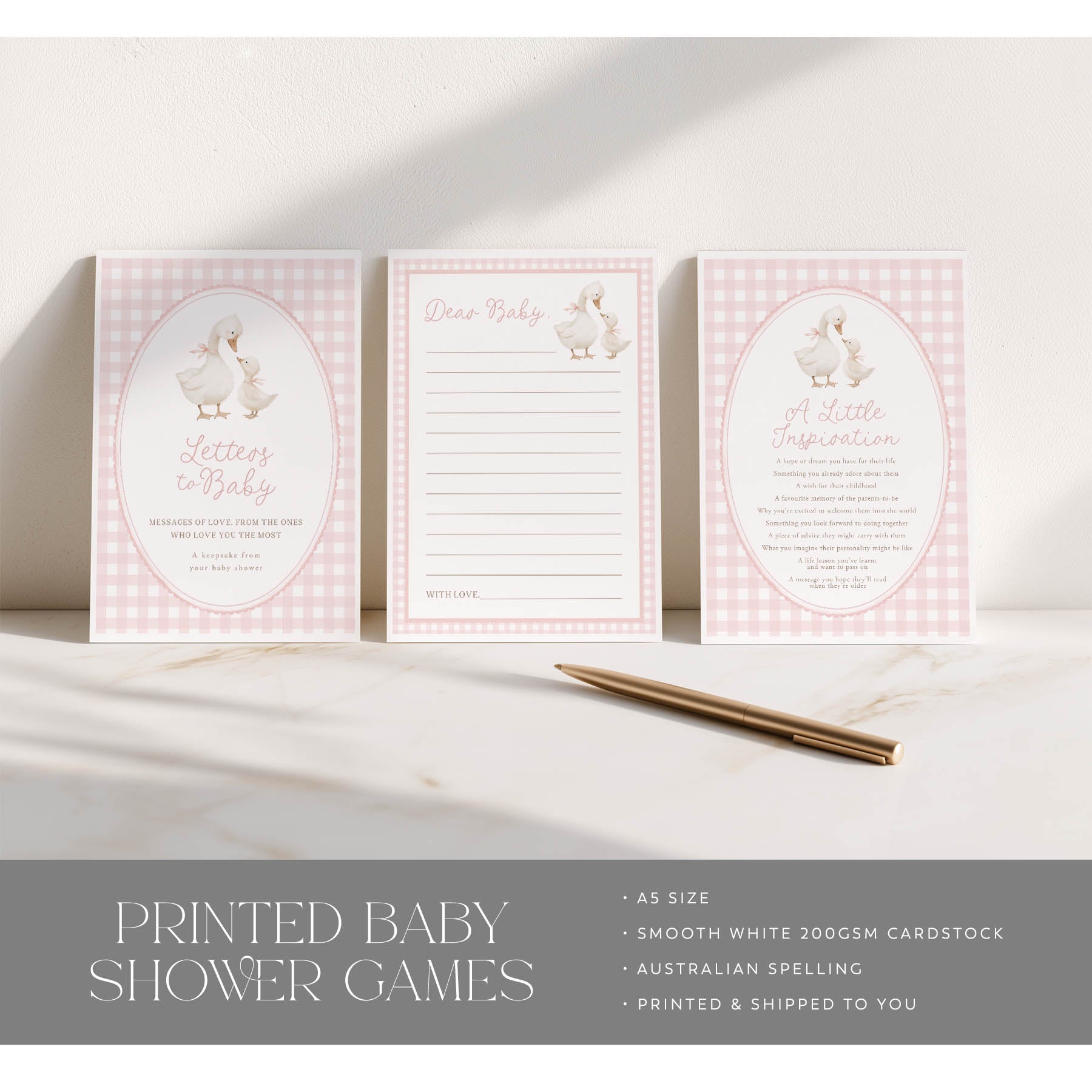 Set of printed baby shower games with pink checkered design on a white surface.