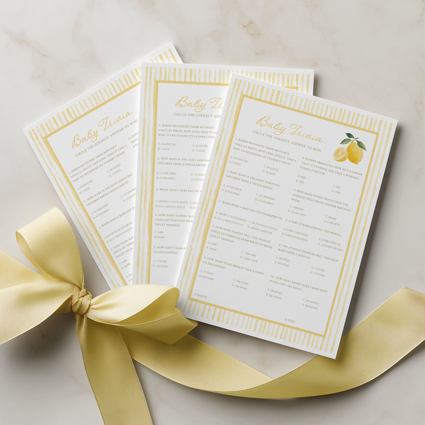 Three baby shower invitations with a yellow ribbon on a light background