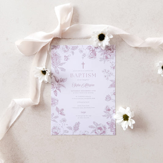 Baptism invitation with floral design and white ribbon on a light background