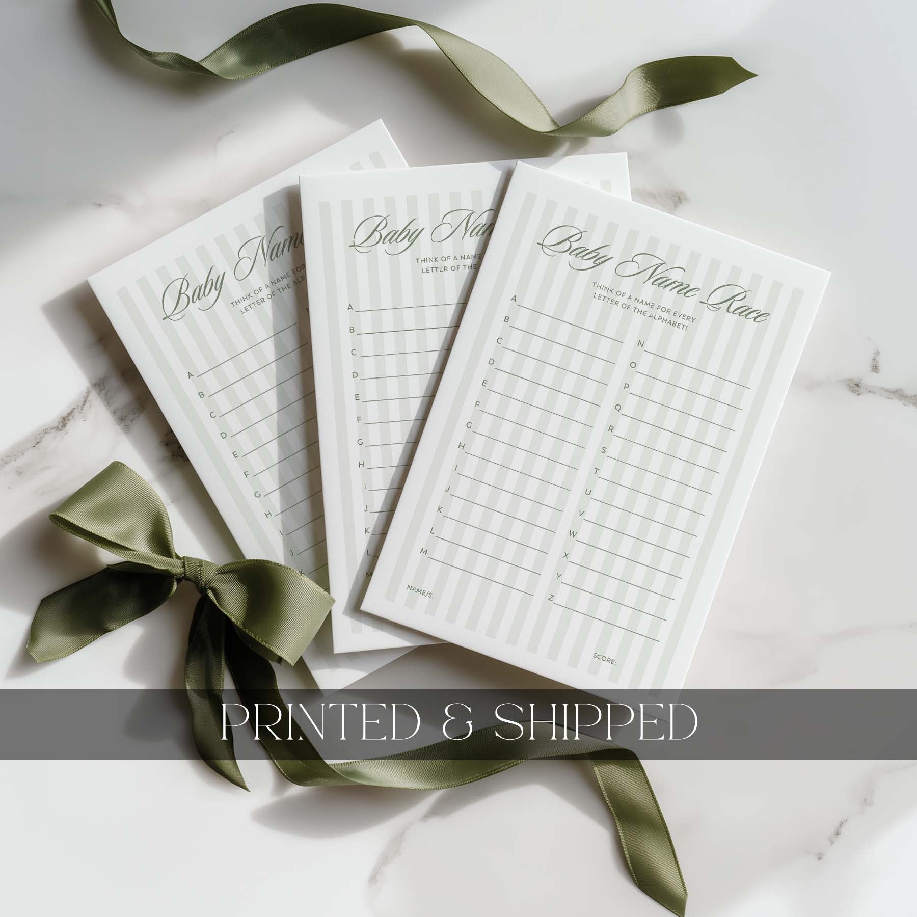 Three green stripe baby shower games with green ribbons on a white surface