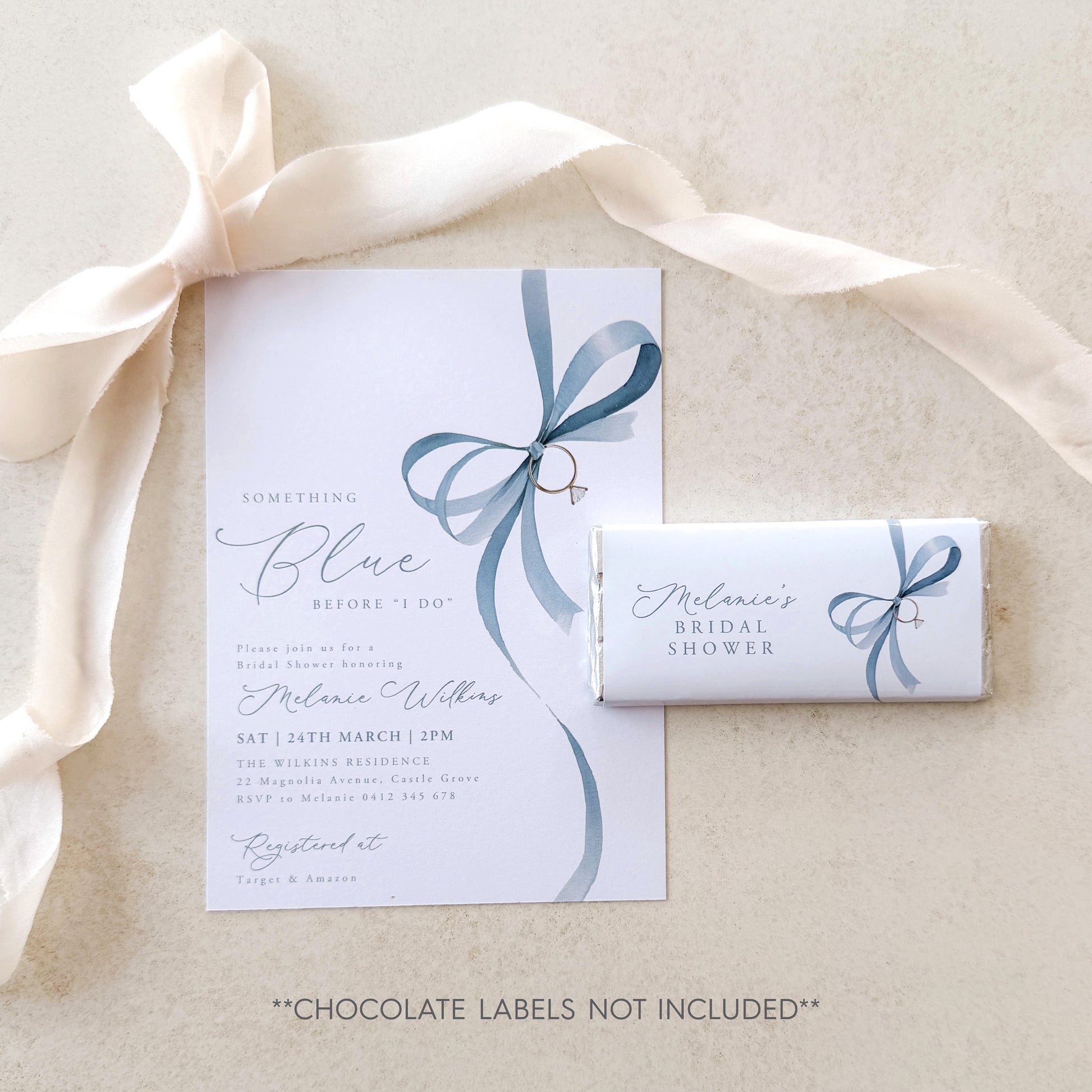 Bridal shower invitation with blue ribbon design and a chocolate bar labeled 'Melanie's Bridal Shower' on a beige background.
