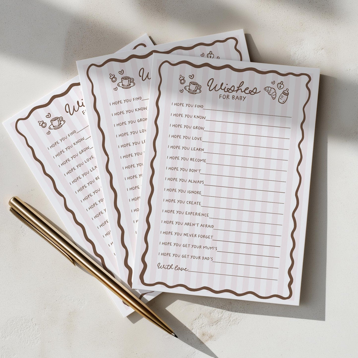 Three baby shower prediction and advice sheets with a pen on a light surface