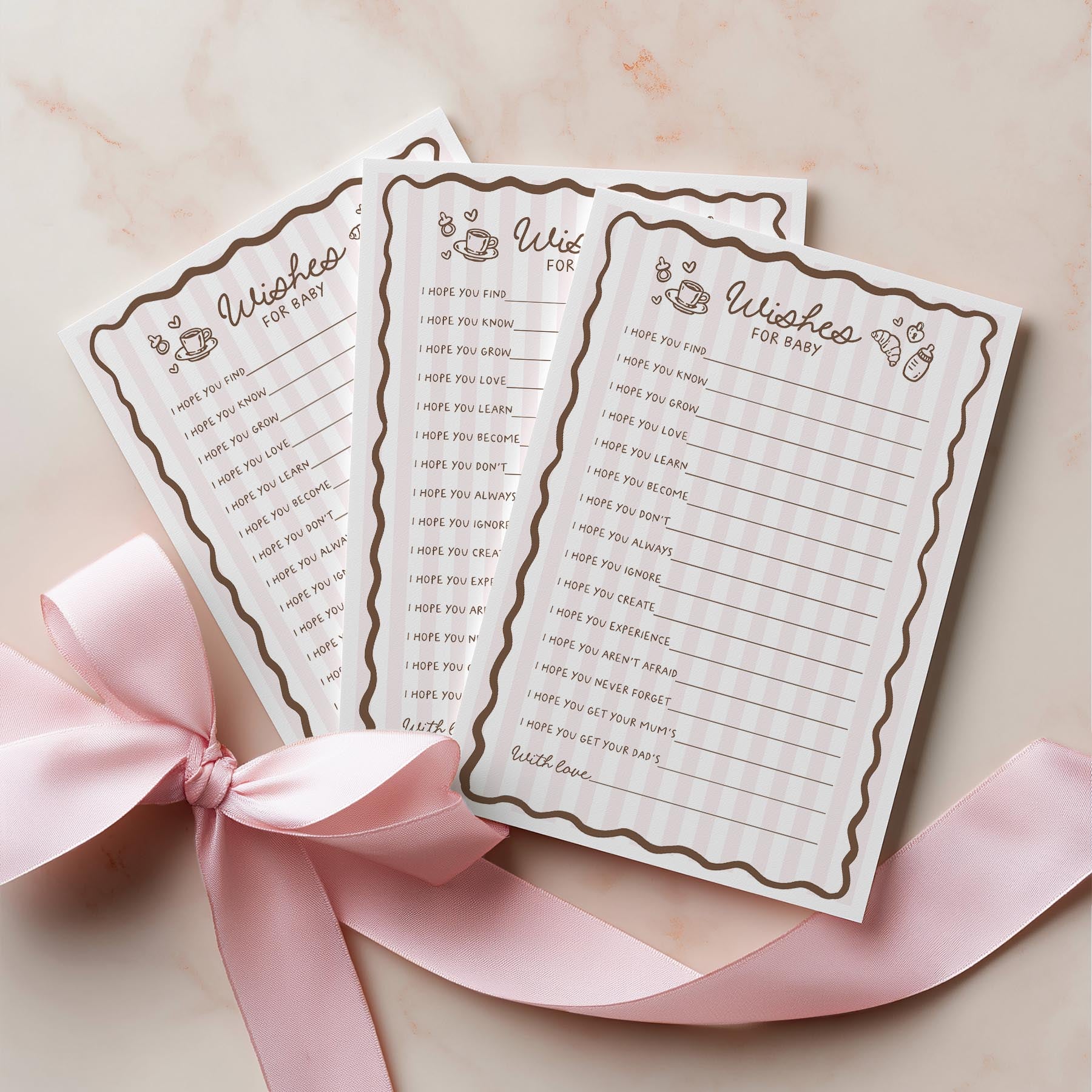 Two baby bingo cards with a pink ribbon on a light background
