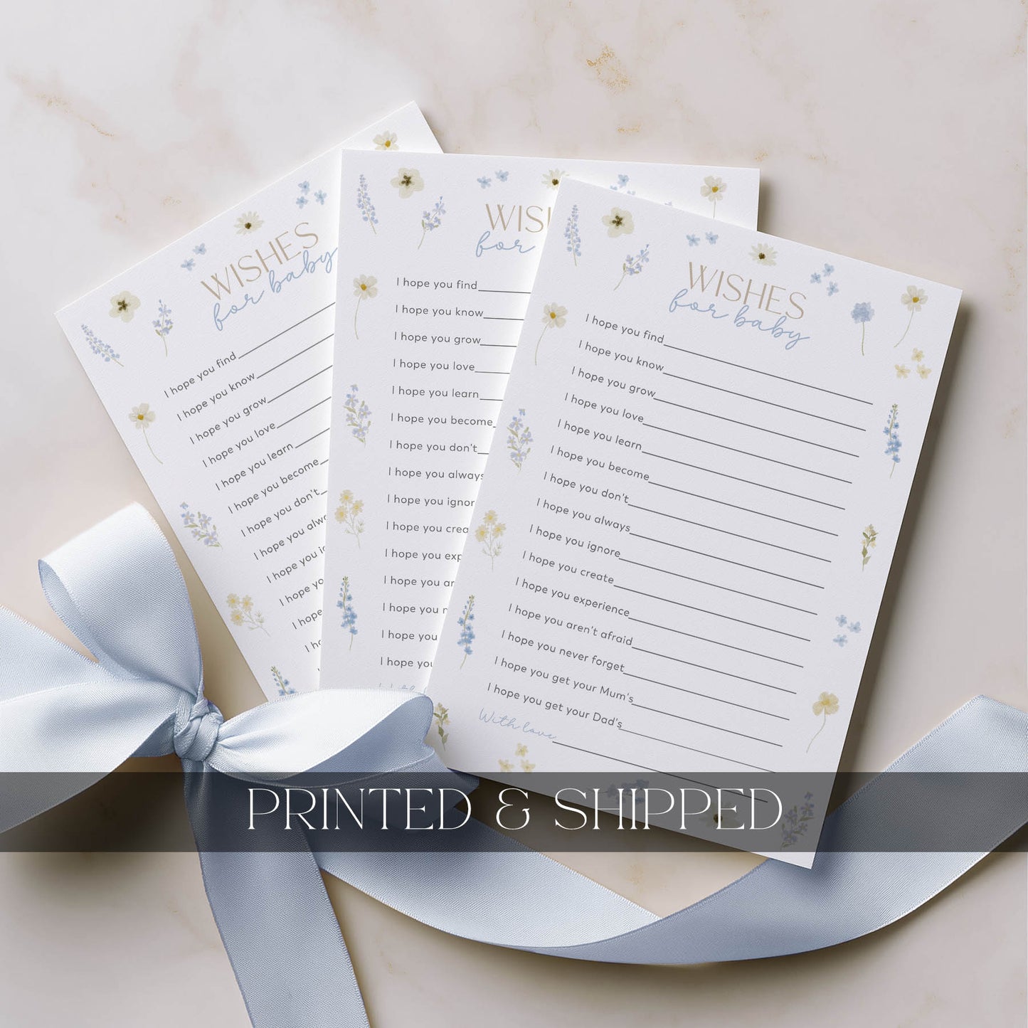 Baby shower printed items with a decorative ribbon on a light background