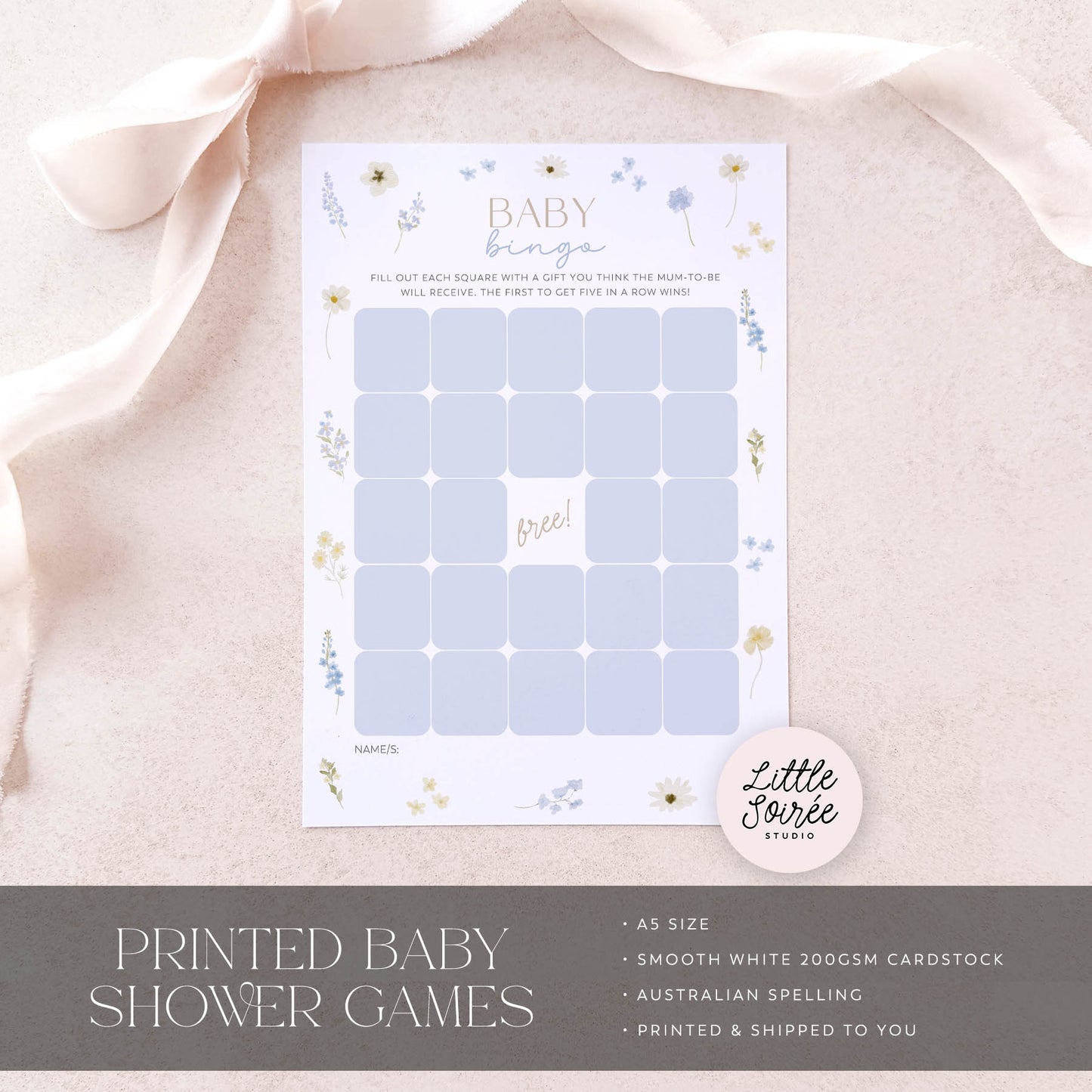 Baby shower game card with floral designs on a soft pink fabric background