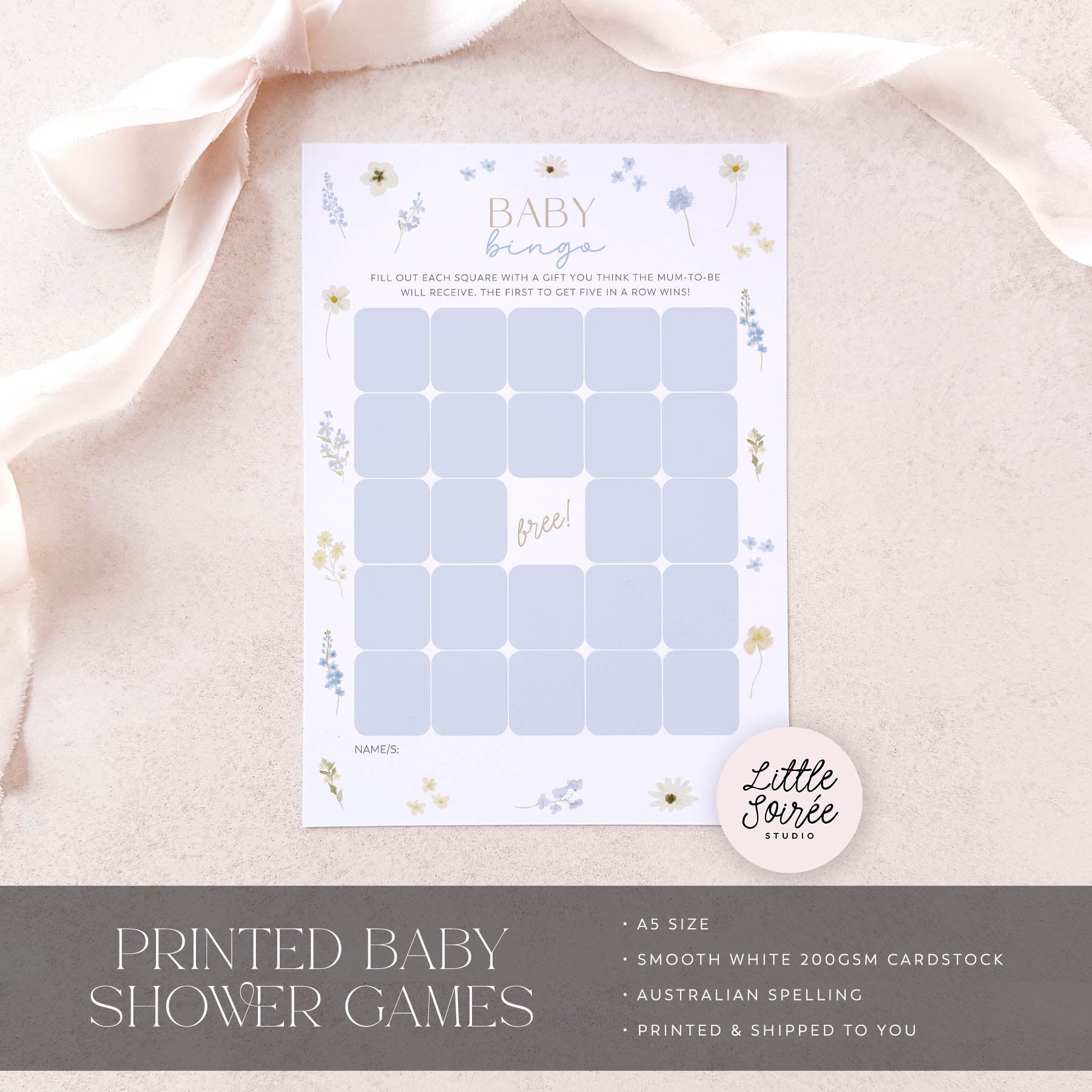 Baby shower game card with floral designs on a soft pink fabric background