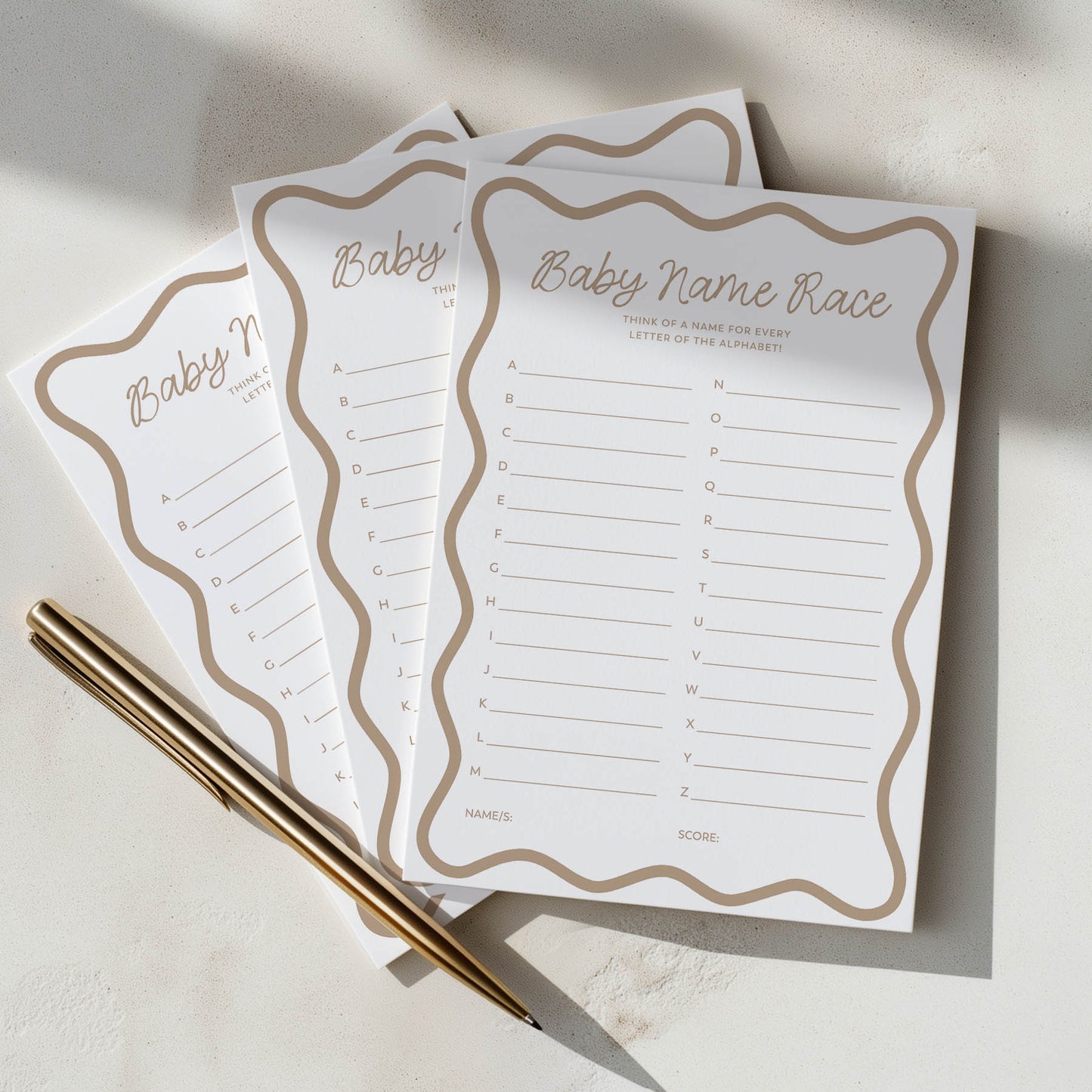 Three baby name race sheets with a pen on a light surface