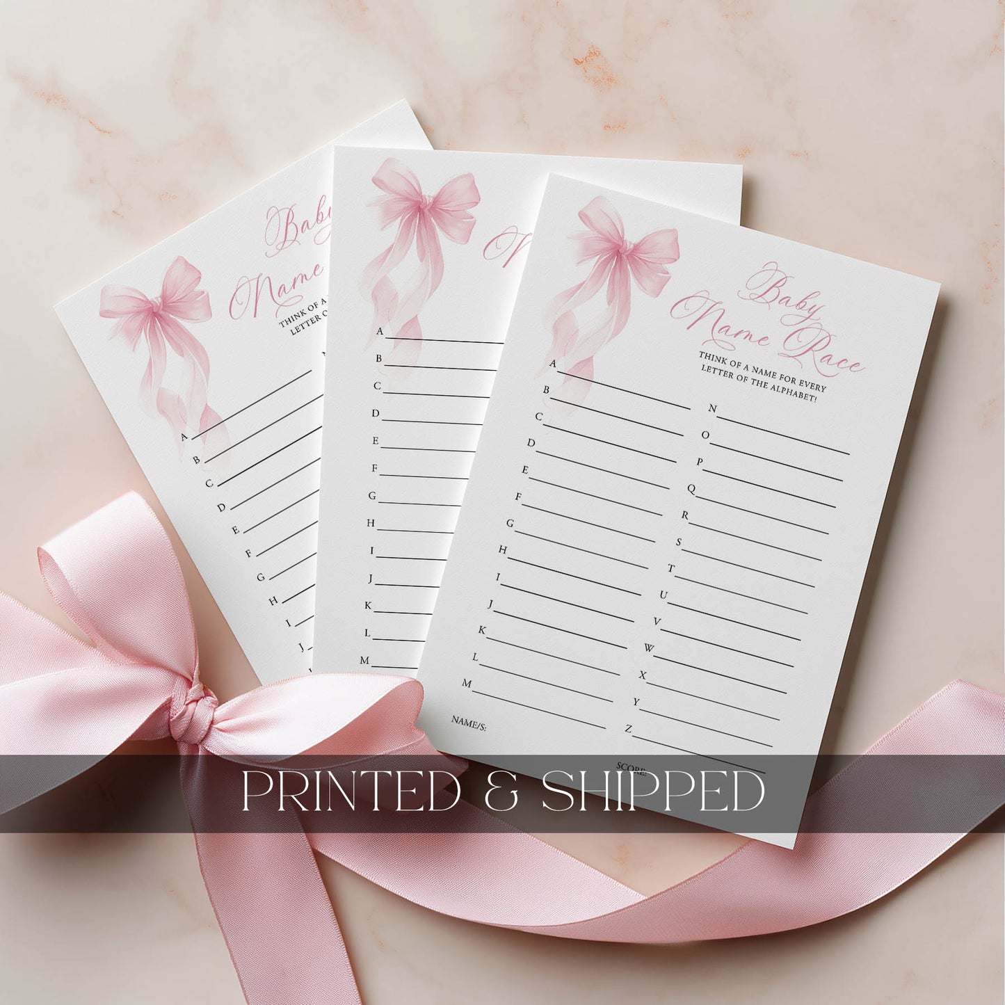 Three baby name place cards with pink ribbons on a light background