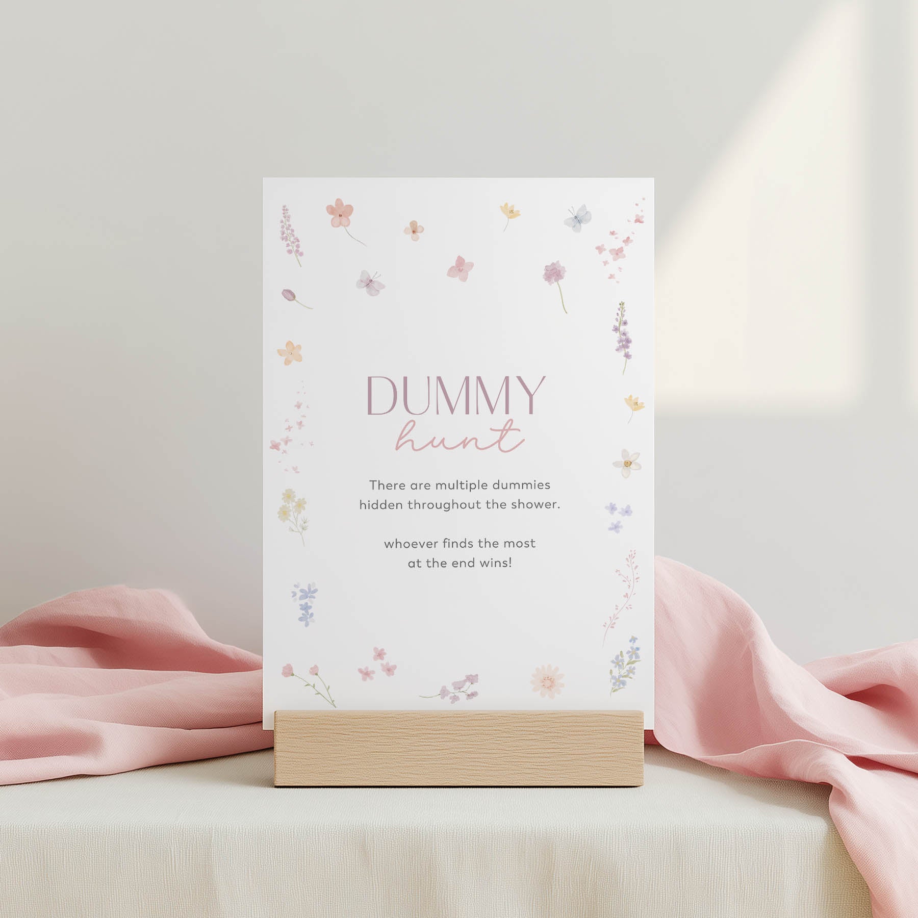 Floral-themed baby shower game card with pink ribbon on a light background