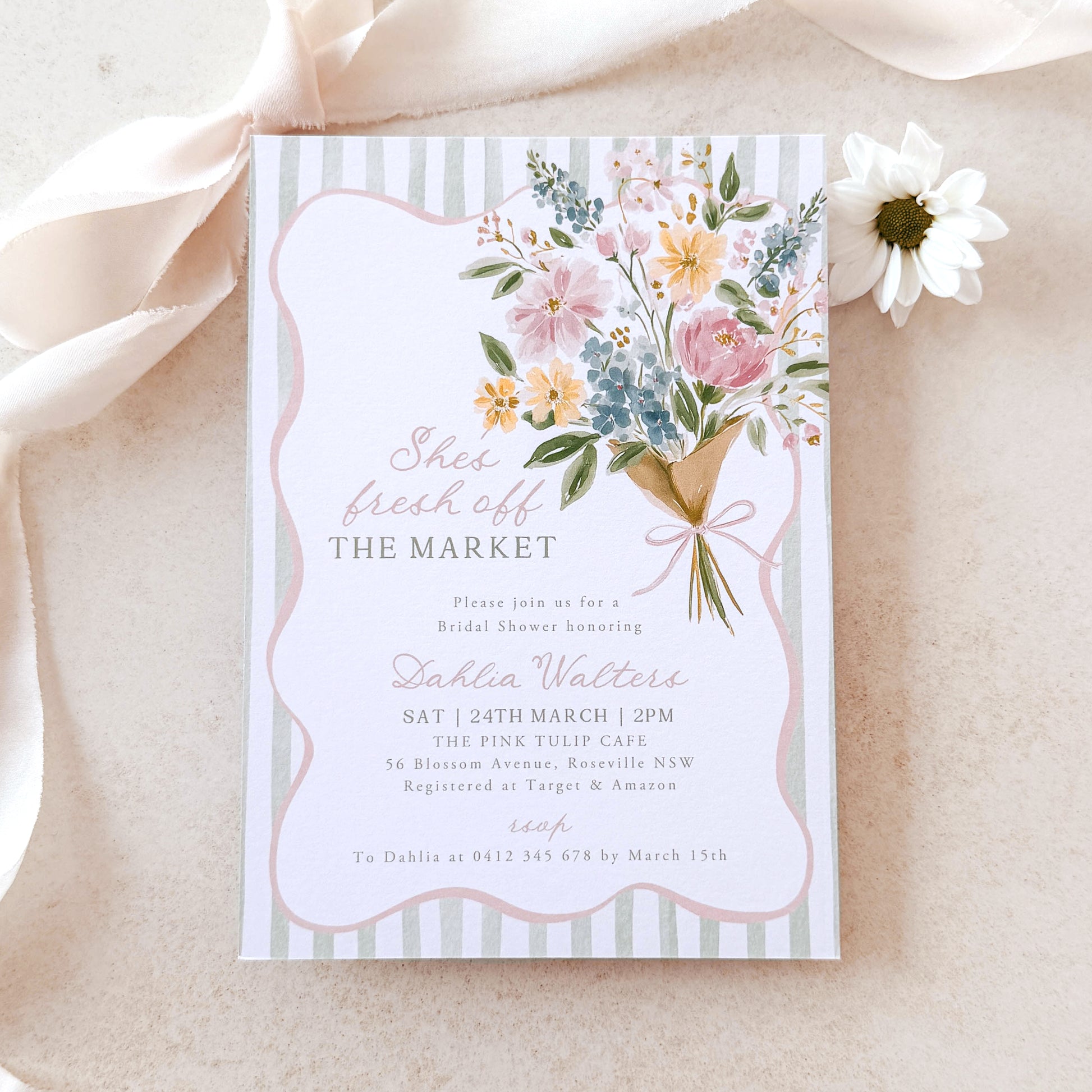 Floral invitation card on a soft beige background with ribbons and flowers.
