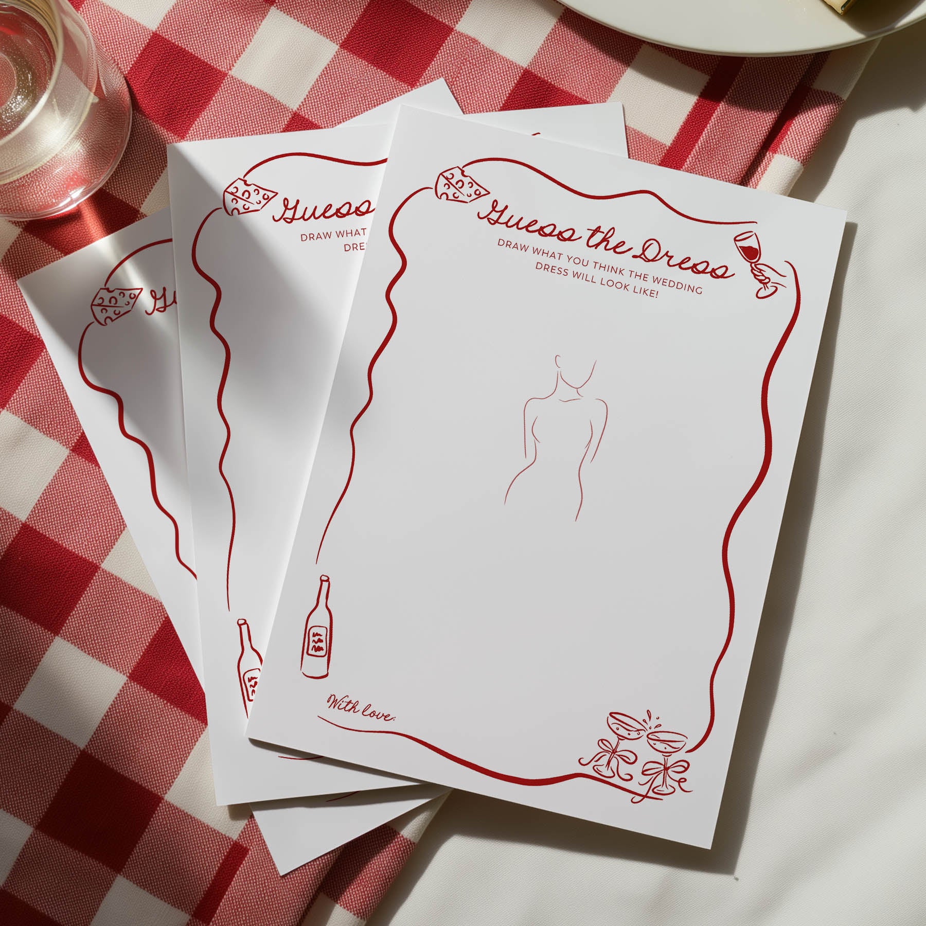 Set of 'Guess the Dress' cards on a red and white checkered tablecloth.