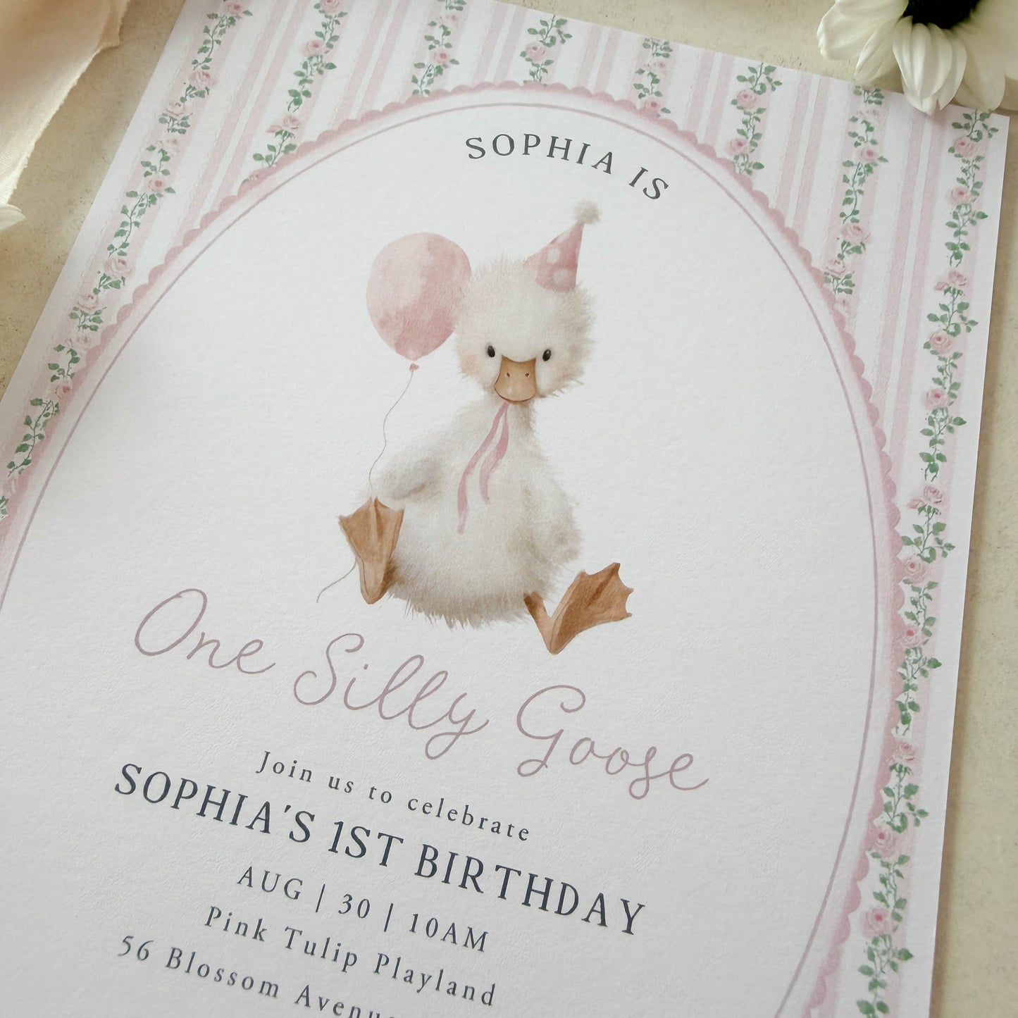 Invitation card with a goose illustration and birthday details on a floral background