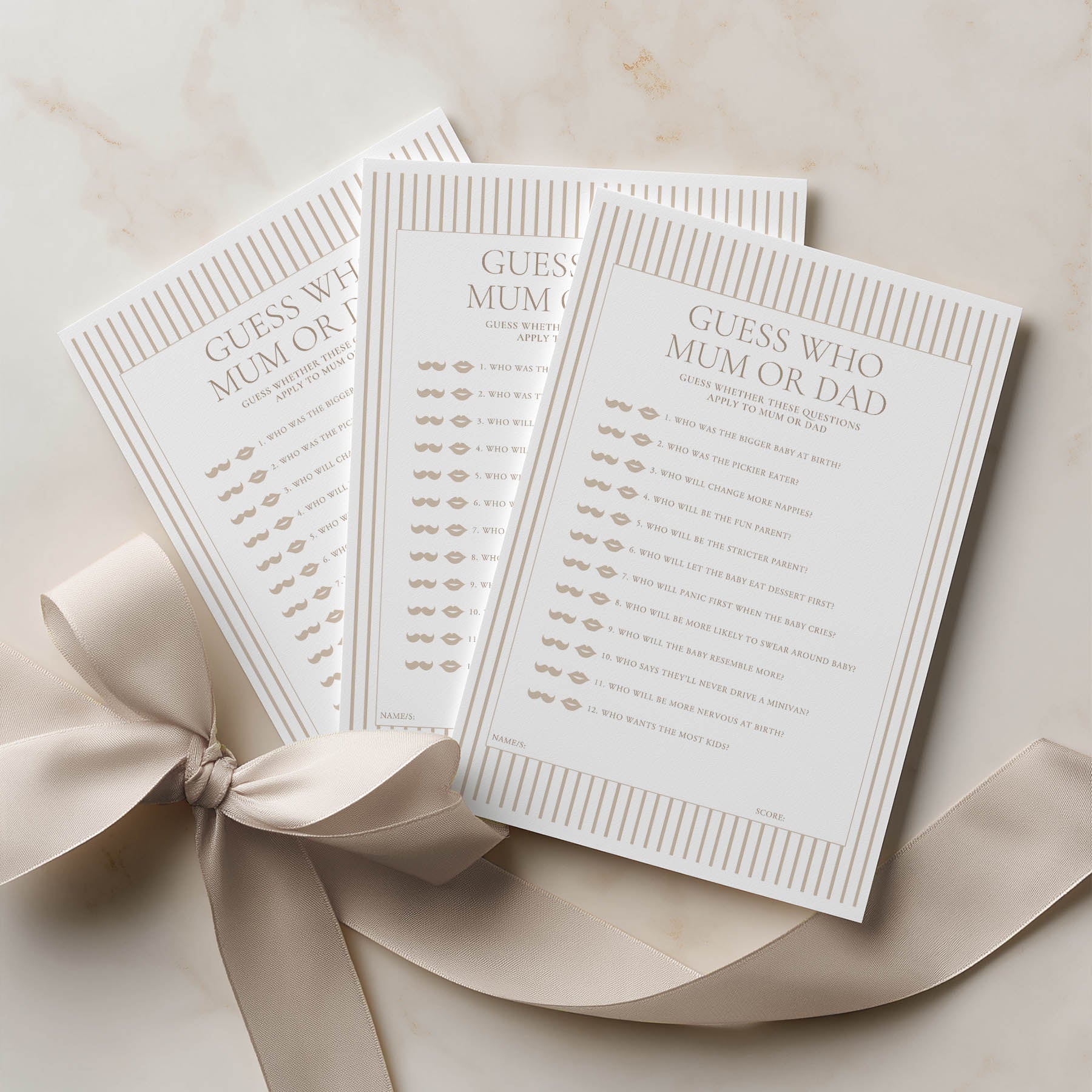 Three 'Guess Who Mum or Dad' cards with a ribbon on a beige background