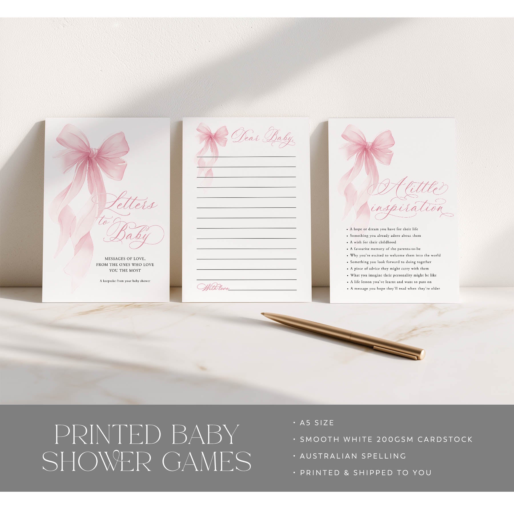 Set of printed baby shower games with pink bows on a marble surface