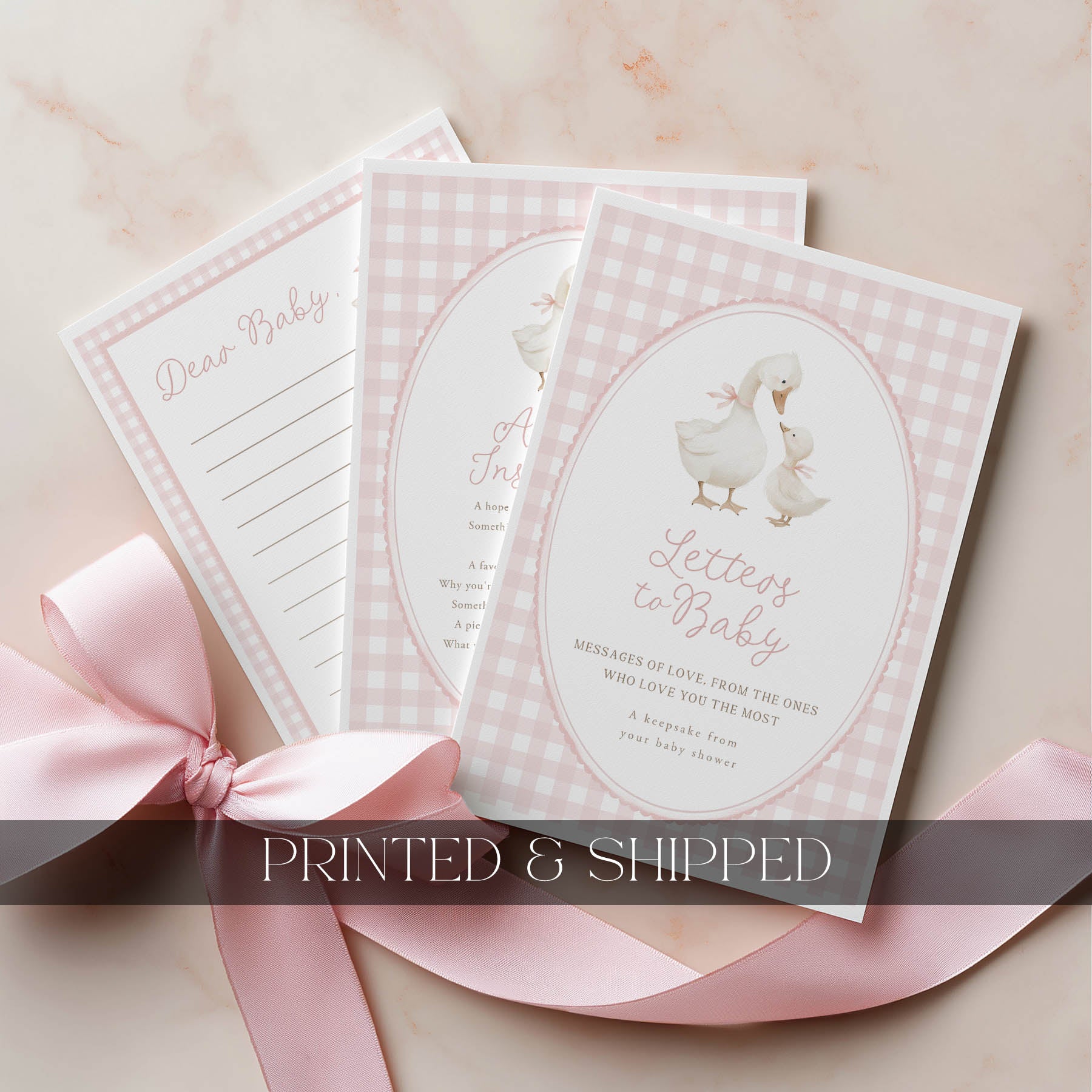Set of baby shower cards with a pink checkered design and a pink ribbon on a light background.