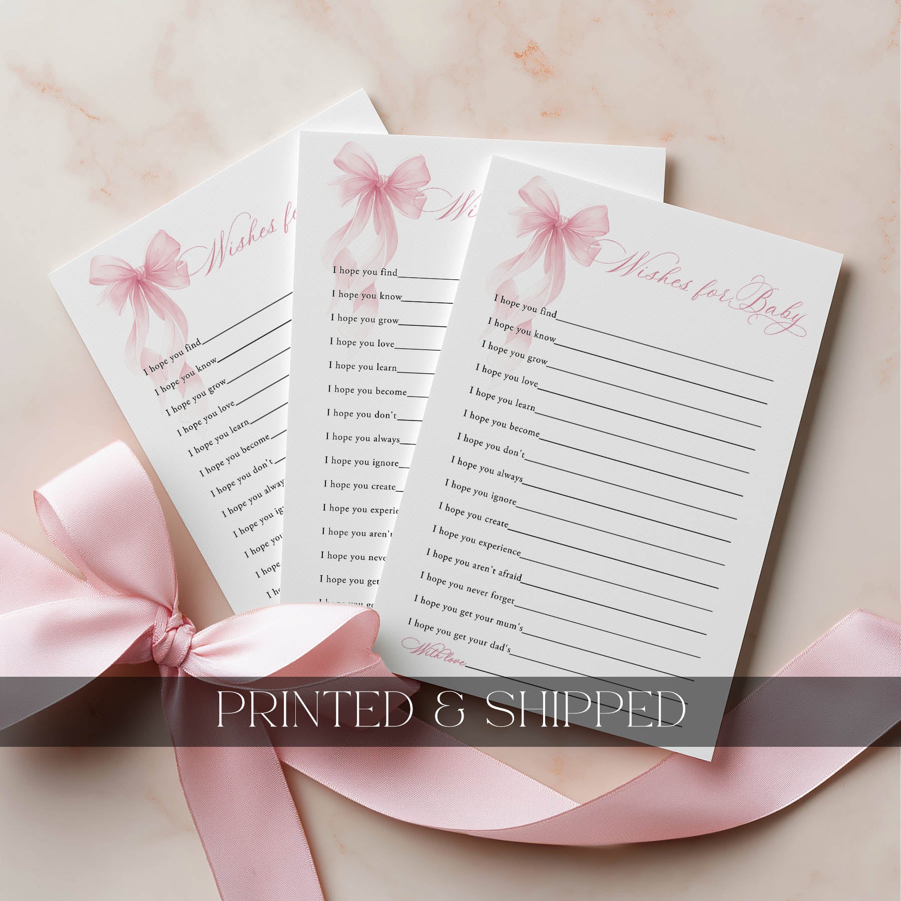 Three sheets of paper with 'Wishes for Baby' text and pink ribbons on a light background.