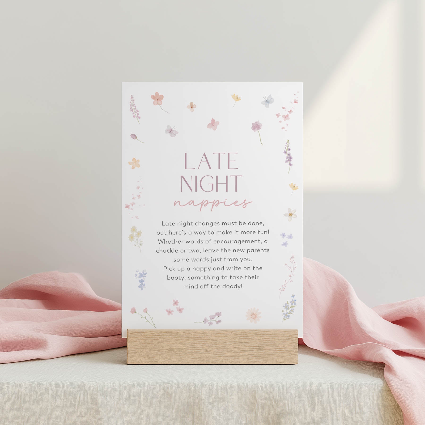 Card with 'Late Night Nappies' text on a stand with pink fabric in the background
