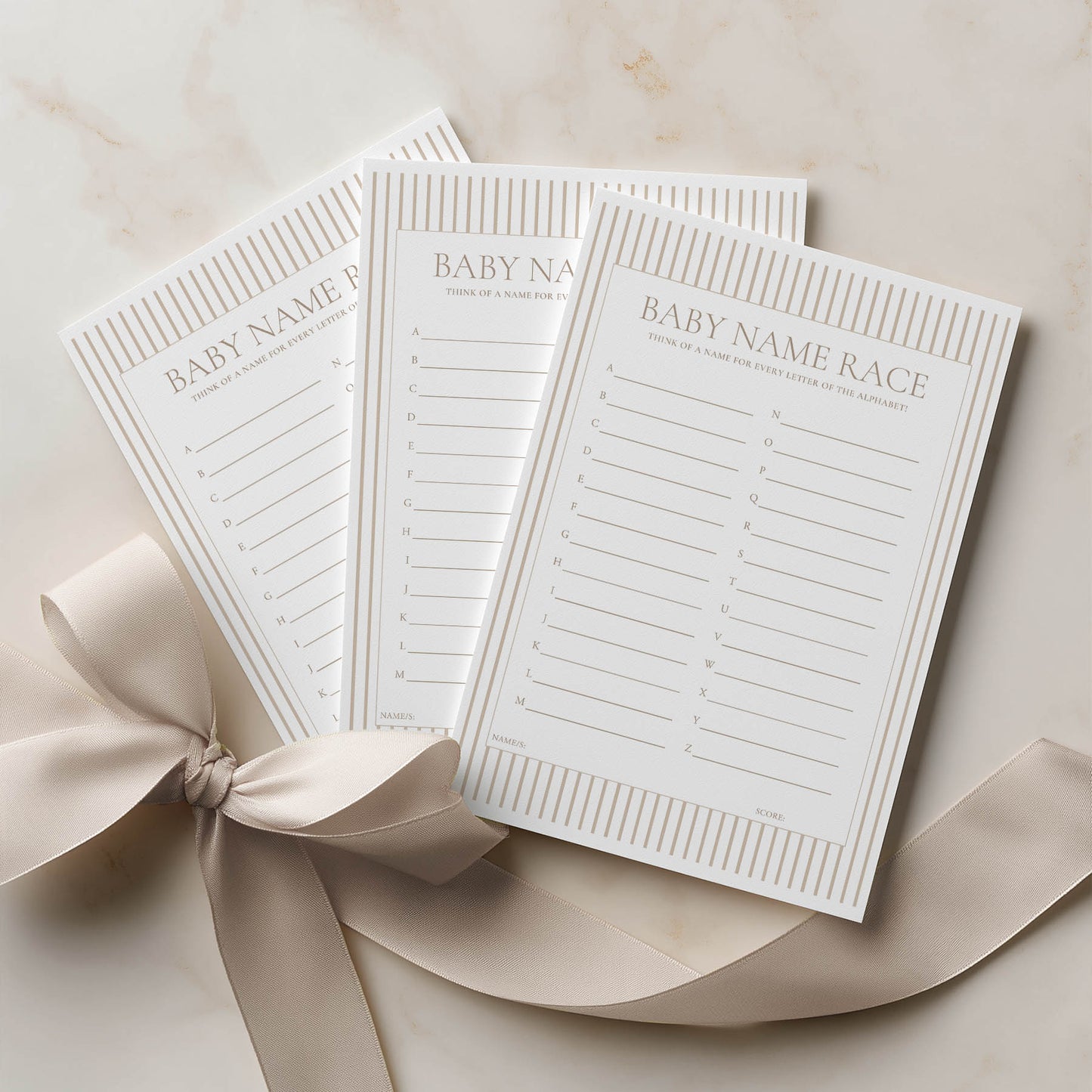 Three 'Wishes for Baby' cards with a ribbon on a beige surface
