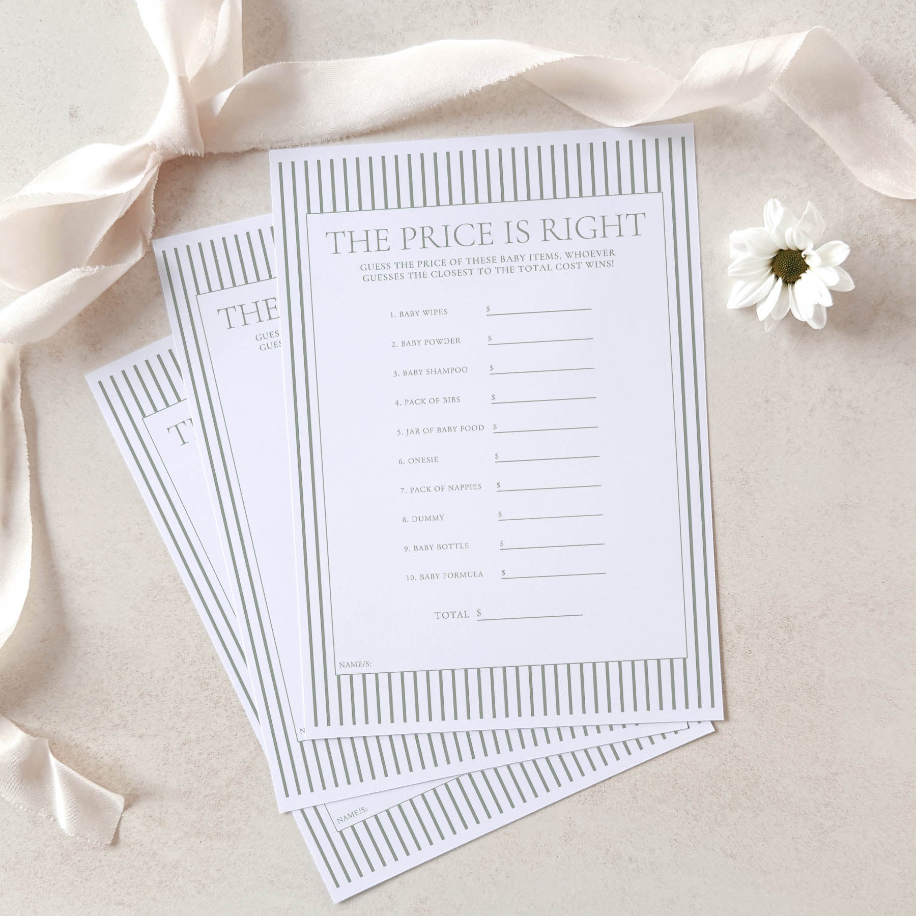 Two 'The Price is Right' game sheets on a beige surface with a white flower and satin ribbon.