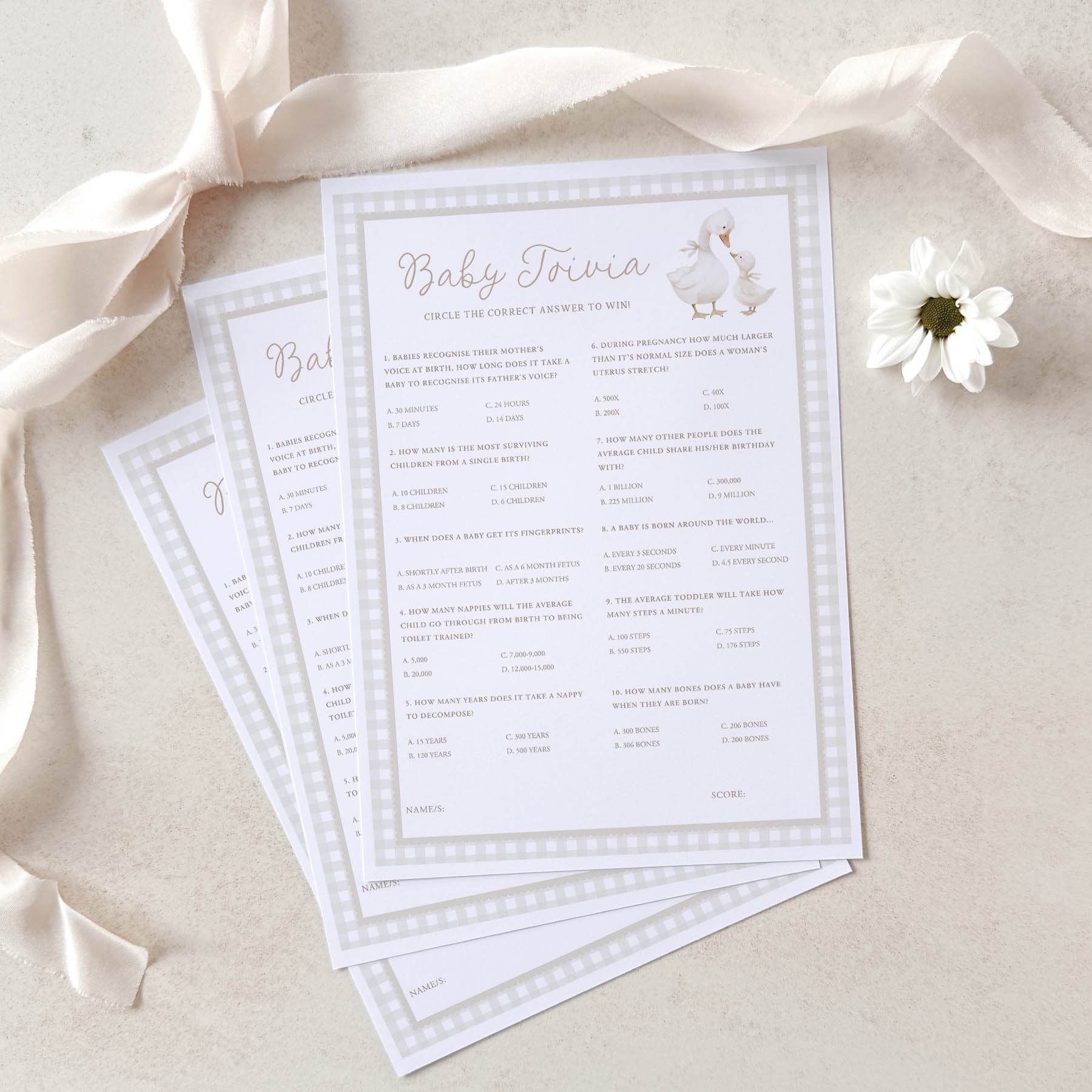 Baby shower game cards with ducks on a beige background with ribbons and a flower.