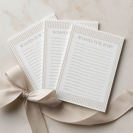 Three 'Wishes for Baby' cards with a ribbon on a beige surface